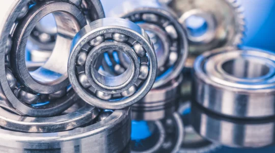 Un technicien inspecte les roulements à billes d'un convoyeur dans un entrepôt automatisé.